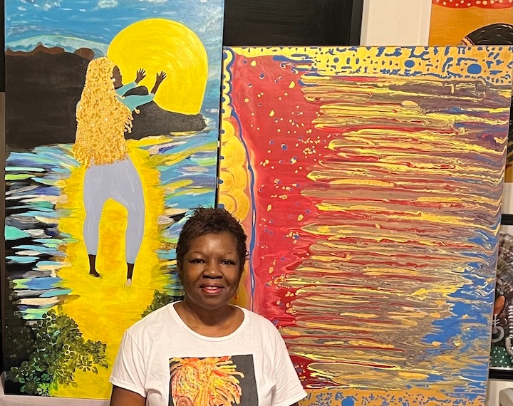 woman in front of her two painitings